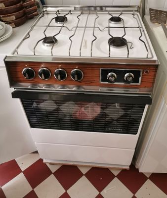 une cuisinière installée dans une cuisine au sol carrelé en damier