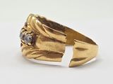 a close up of a gold ring with a red stone