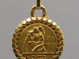 a close up of a gold medal with a woman holding a child