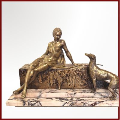 une statue représentant une femme assise sur un banc à côté d'un chien