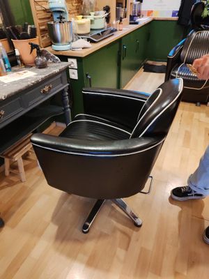 un homme debout dans une pièce où se trouve une chaise