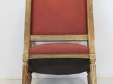 a red chair with a wooden frame and a red cushion