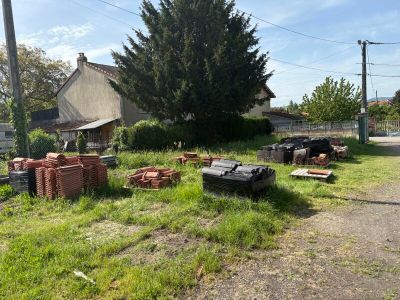 a pile of bricks sitting on the grass in front of a house
