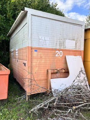 a pile of twigs in front of an old trailer