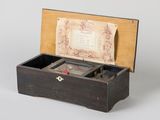an old wooden box with a note in it sitting on a table