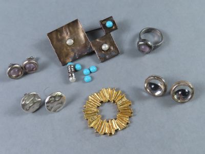 tout un tas de bagues et de boucles d'oreilles différentes posées sur une table