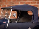 a blue car parked in front of a brick wall
