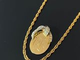Gros plan sur un collier en or sur lequel se trouve une pièce de monnaie