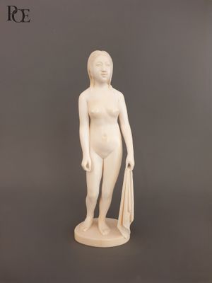 statue d'une femme tenant un sac et une raquette de tennis