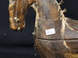 a wooden toy horse that is sitting on a black surface