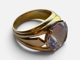 a close up of a gold ring with a purple stone