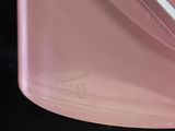 a close up of a pink container with a knife in it