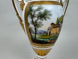 a vase with a painting on it sitting on a table