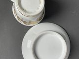 two cups and saucers sitting on top of a table next to each other