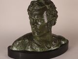 a bronze bust of a man with curly hair on a black base