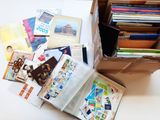 une boîte remplie de livres posée sur une table, à côté d'une pile d'autres livres