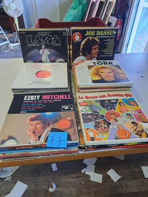 beaucoup de disques vinyles posés sur une table dans une pièce