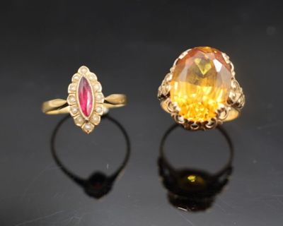 une paire de bagues ornées de saphirs jaunes et de diamants, posées sur un fond noir