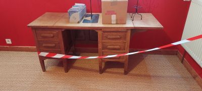 un bureau sur lequel se trouve une boîte, avec un mur rouge en arrière-plan