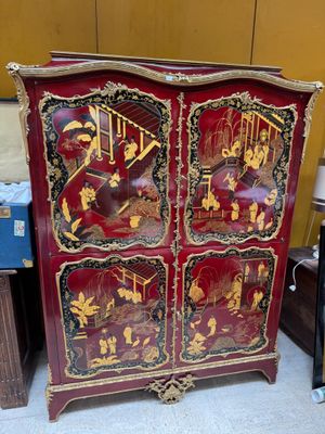 a red cabinet with gold and black designs on it