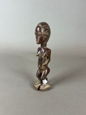 une vieille figurine en bronze représentant un garçon sur un skateboard