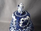 a blue and white bell with a bird on top