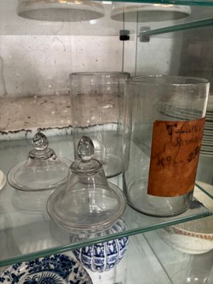 a glass shelf that has a lot of glass jars on it
