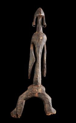 une sculpture en bois représentant une femme debout sur une branche d'arbre