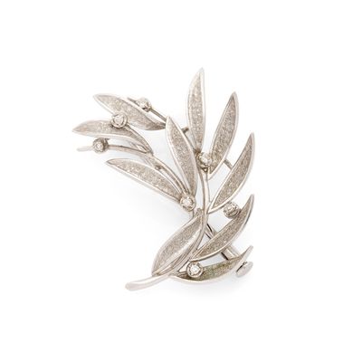 un gros plan d'une broche en argent ornée de feuilles