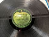 vinyl record with a green apple on top of it on a table