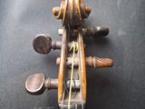 an old violin sitting on top of a black table next to a chair