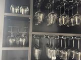 many wine glasses that are hanging on the wall