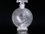 an image of a glass perfume bottle on a reflective surface