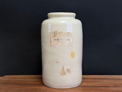 a white vase sitting on a wooden table with a black background