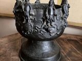 statue représentant un groupe de personnes dans un bol posé sur une table en bois