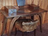 a desk with a mirror and a stool in a room