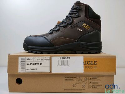 des chaussures de randonnée pour homme dans une boîte posée sur une table