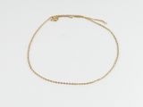 un bracelet de cheville en chaîne d'or orné d'un petit pendentif en forme de cœur