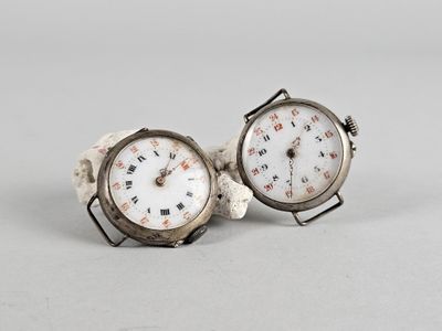 une paire de montres en argent avec des chiffres romains et des chiffres romains