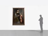 a man that is standing in front of a painting