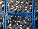 a lot of tires stacked on a rack in a warehouse