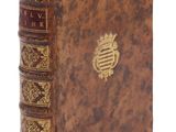 un vieux livre avec un emblème en or sur la couverture