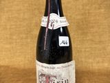 une vieille bouteille de vin posée sur une table en bois