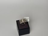 une bague en argent posée sur une boîte noire avec une étiquette de prix