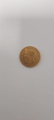 a gold coin sitting on top of a white surface