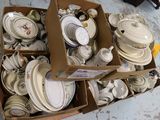une boîte remplie de vaisselle et d'assiettes blanches posée par terre