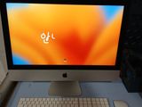 un ordinateur de bureau Apple posé sur un bureau, à côté d'un clavier