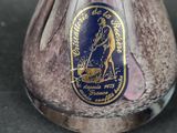 a glass vase with a gold and blue label on it