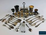 a lot of silverware on a white table