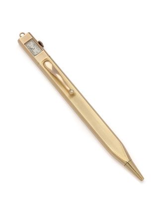 un stylo doré avec une pointe métallique sur fond blanc